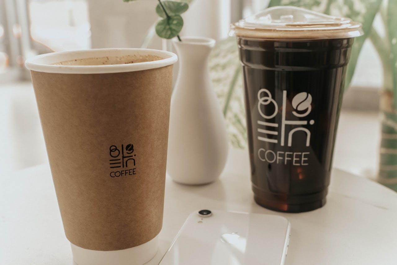 services-01 A close-up of two coffee cups on a white table with minimalist decor.