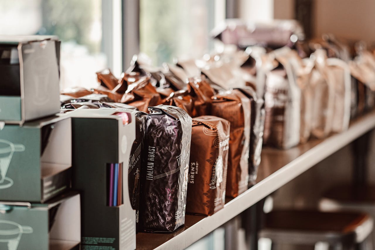 gallery-3 A variety of coffee bags neatly arranged on a shelf in an inviting café.